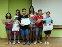 Sara, coordinadora del proyecto Mascotas prohibidas, entregando sus premios a los niños ganadores del concurso de dibujo.
